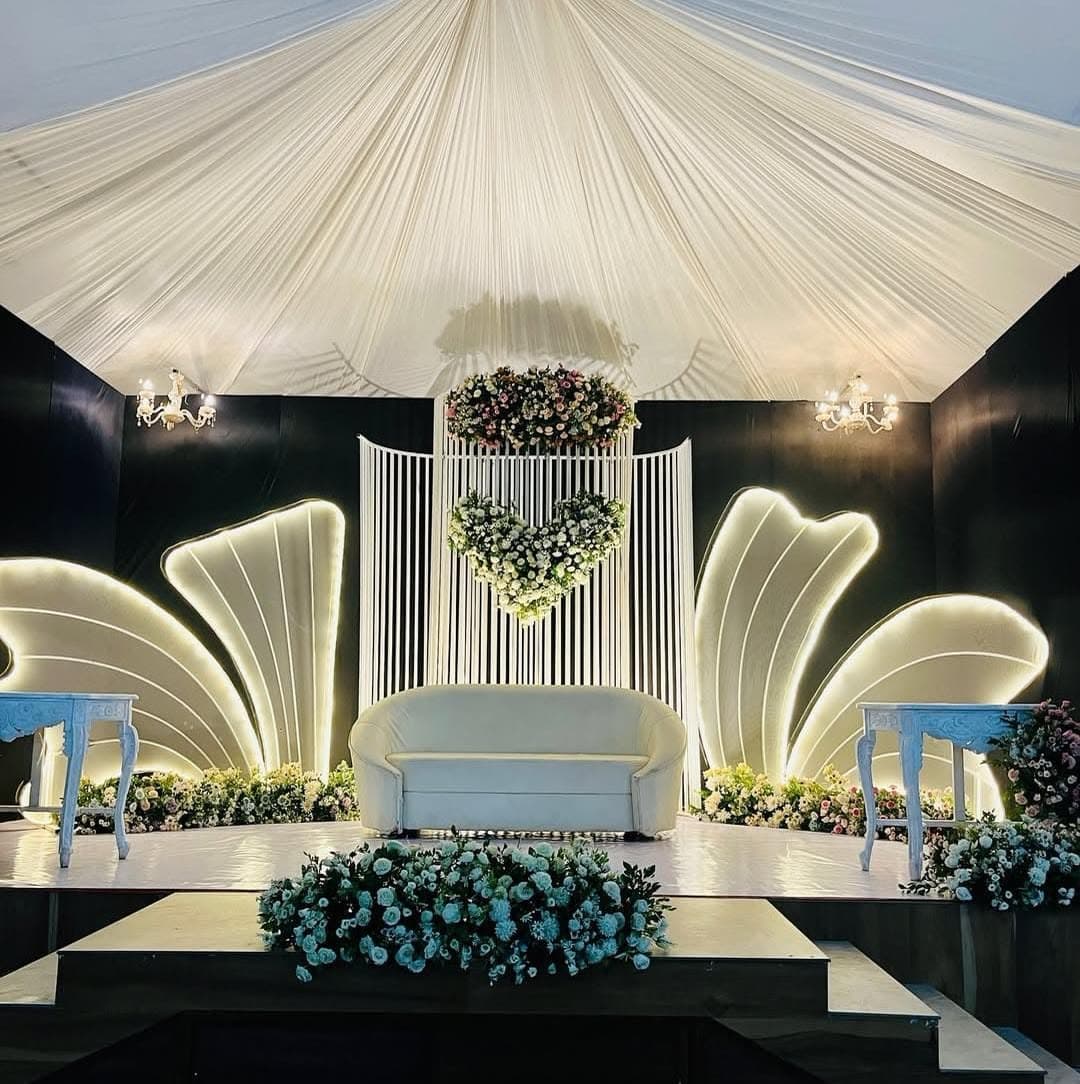 White draped hall with crystal chandeliers and a softly lit aisle